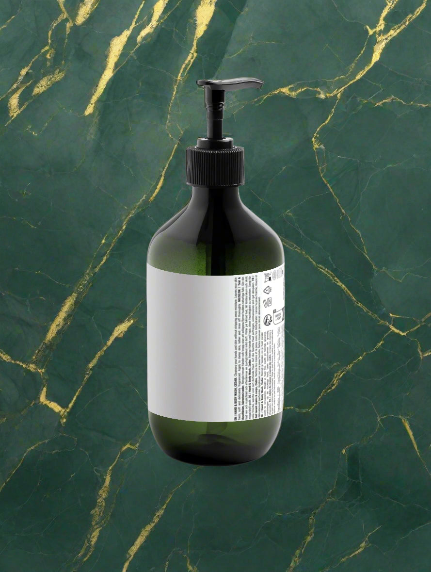 Green bottle with pump and white label on a light gray background